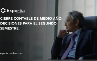 Directivo pensativo mirando hacia la ventana, en referencia al cierre contable de medio año y la toma de decisiones empresariales
