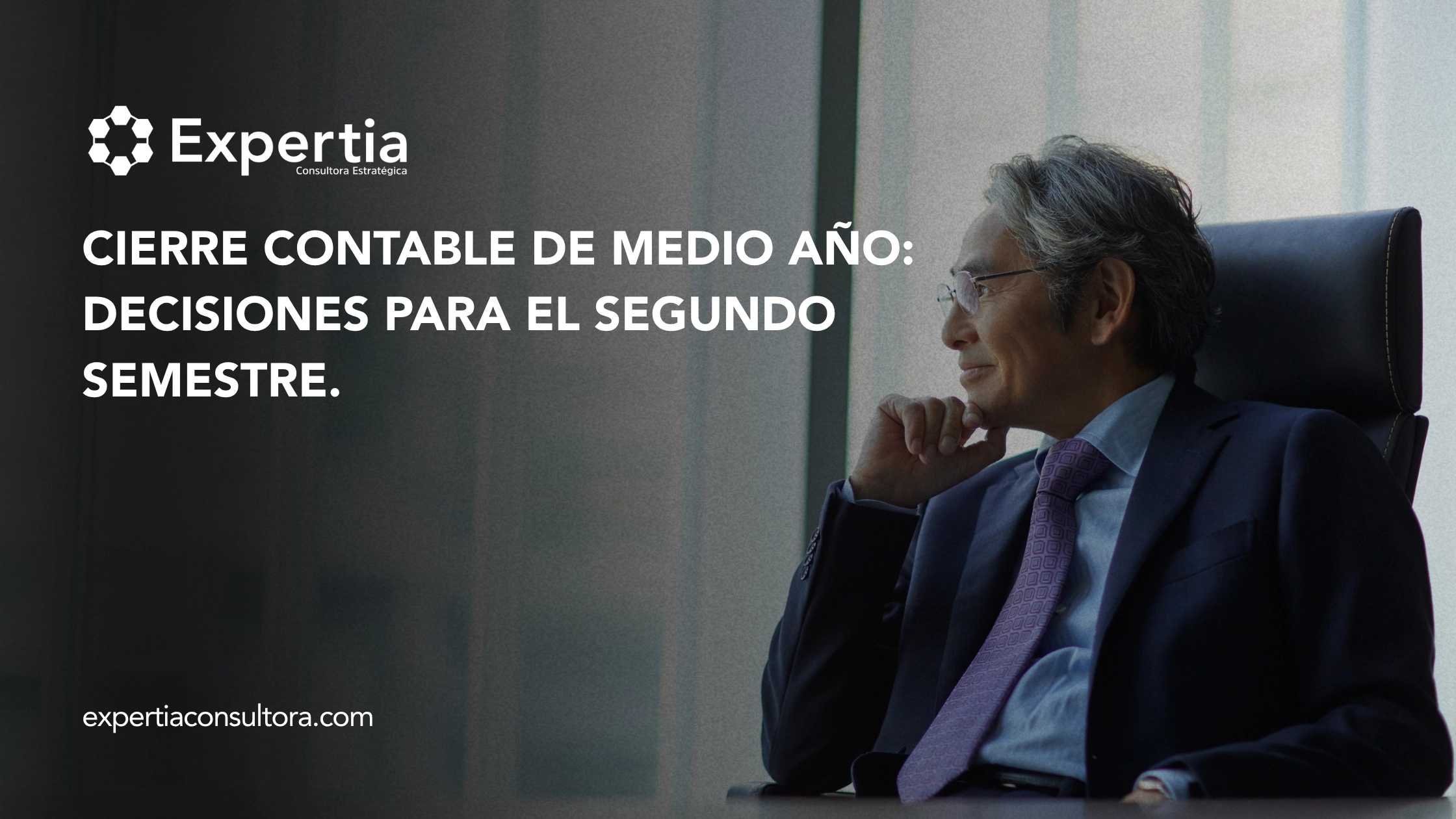 Directivo pensativo mirando hacia la ventana, en referencia al cierre contable de medio año y la toma de decisiones empresariales